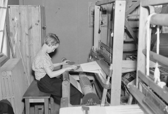 girl using loom to weave