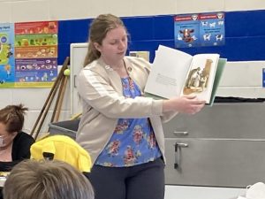 photo of Kendy Bostic reading a book to students